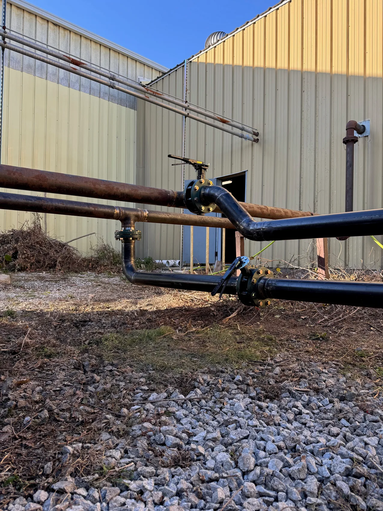 Exterior 4-inch black-iron process piping with flanged valves along a building by Sons of Thunder Welding